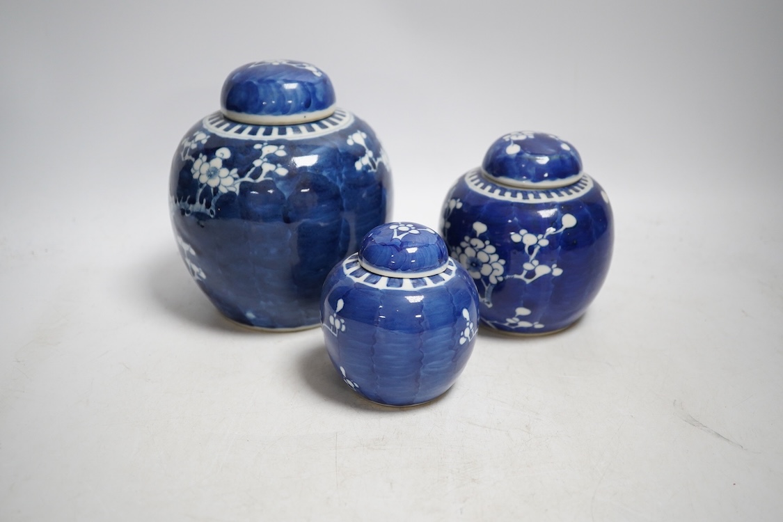 Three late 19th century Chinese blue and white prunus jars, tallest 15cm. Condition - one cover broken in two and re-glued, otherwise good